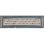 A KELIM RUNNER with three rows of twenty-two medallions. 9ft long x 2ft 3ins wide.