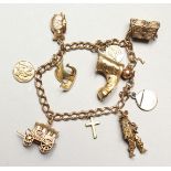 A 9CT GOLD CHARM BRACELET with 10 charms including Christian icons 37gmS.