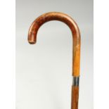 AN EDWARDIAN BENTWOOD CANE with silver handle, dated 1919. 35ins long.