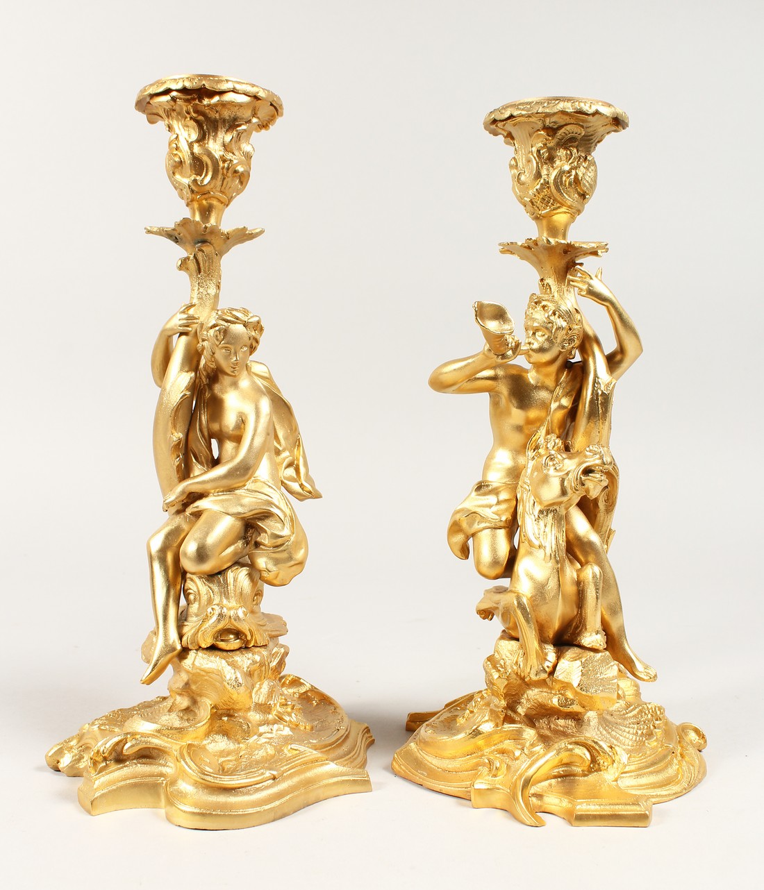 A GOOD PAIR OF GILT BRONZE CLASSICAL CANDLESTICKS on scrolled base. 11.5 ins tall