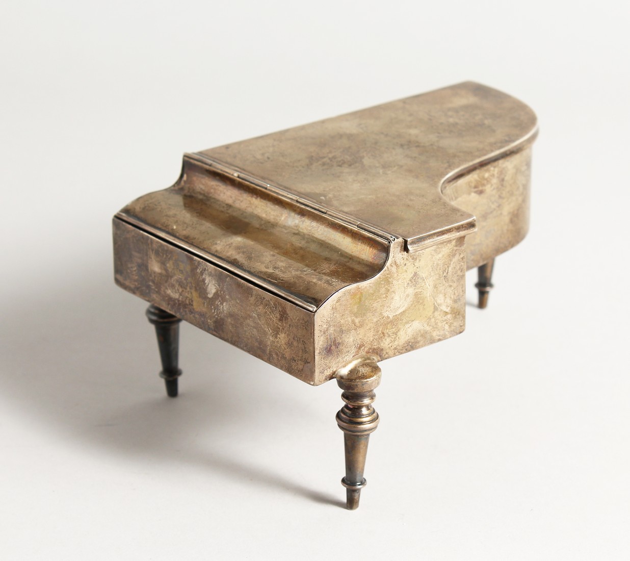 A NOVELTY SILVER PIANO JEWELLERY AND RING BOX, formed as a piano on tuned legs. London 1906. 7ins