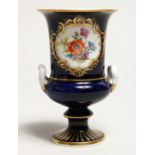 A SMALL MEISSEN TWO HANDLED URN on a blue ground painted with a panel of flowers. Cross swords