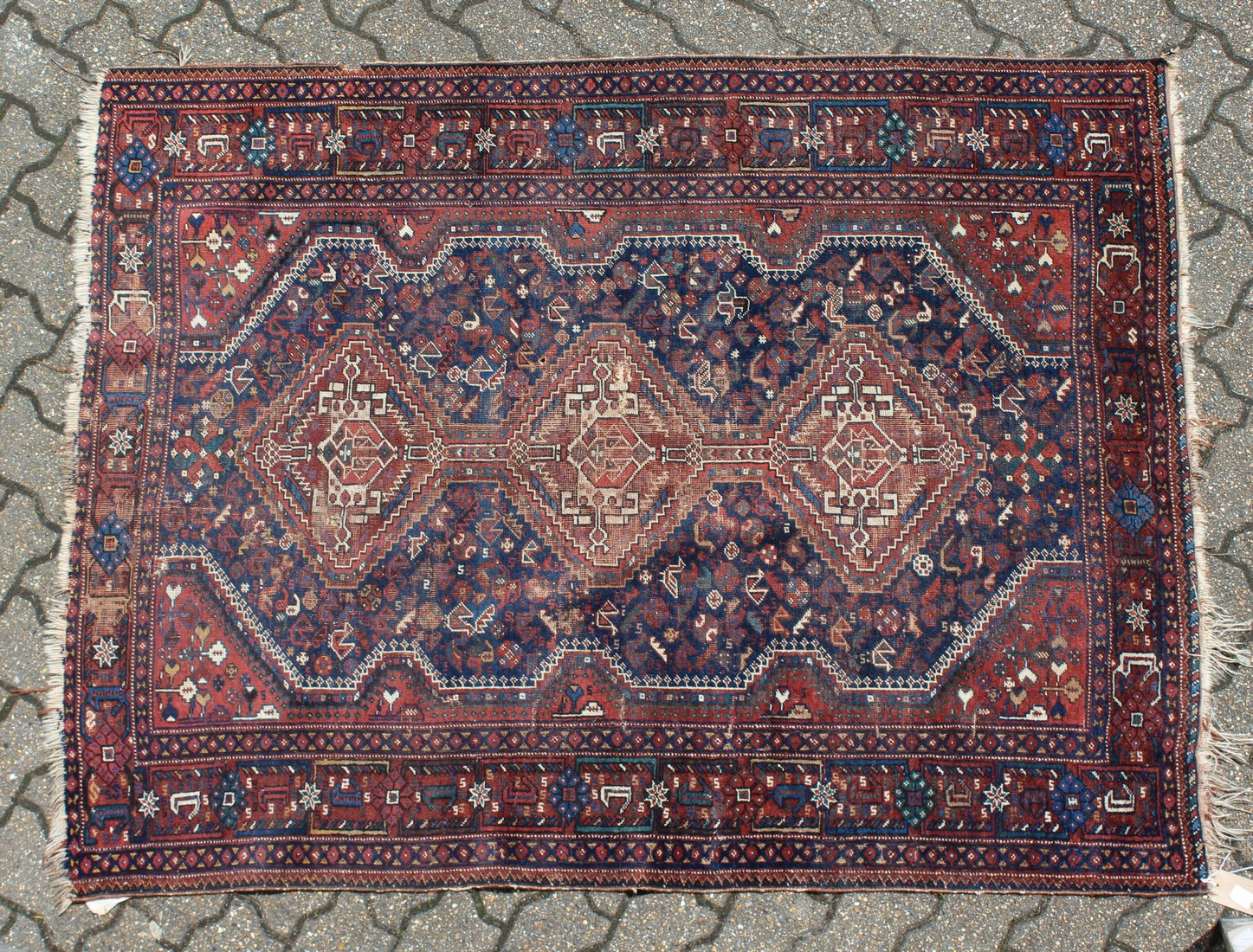 AN OLD PERSIAN RUG with three medallions (worn). 5ft 5ins long x 4ft 6 ins wide.