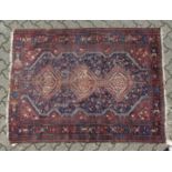 AN OLD PERSIAN RUG with three medallions (worn). 5ft 5ins long x 4ft 6 ins wide.