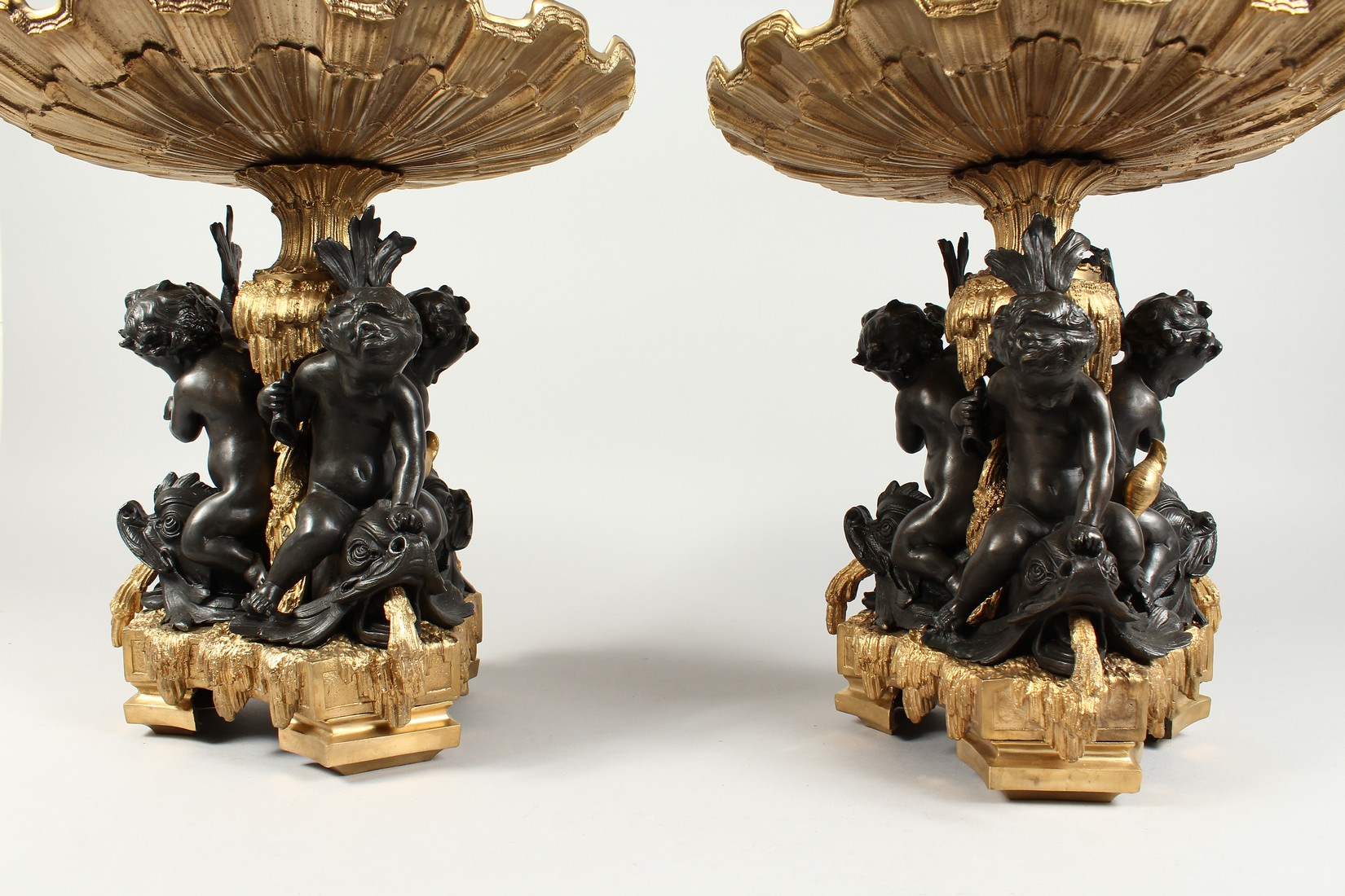 A GOOD PAIR OF BRONZE AND GILT BRONZE COMPORTS with shell shaped tops, three cupid supports. 13ins - Image 4 of 5