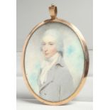 A GEORGIAN OVAL MINIATURE OF A YOUNG MAN, half length in a gilt frame. 2.75ins x 2ins.