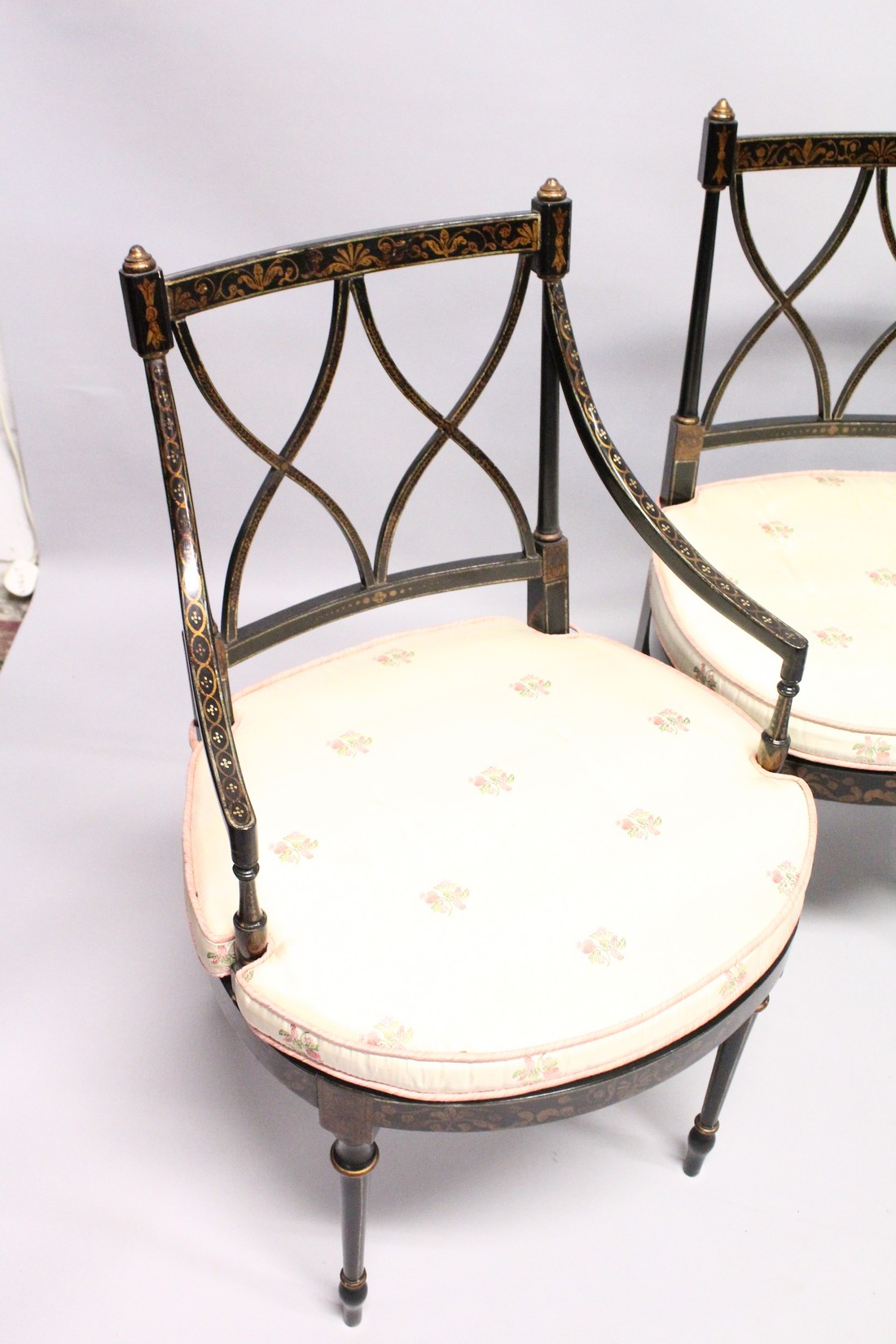 A SET OF FOUR BLACK AND GILT CHAIRS, two with arms, with cross fret backs and cane seats. - Image 2 of 4