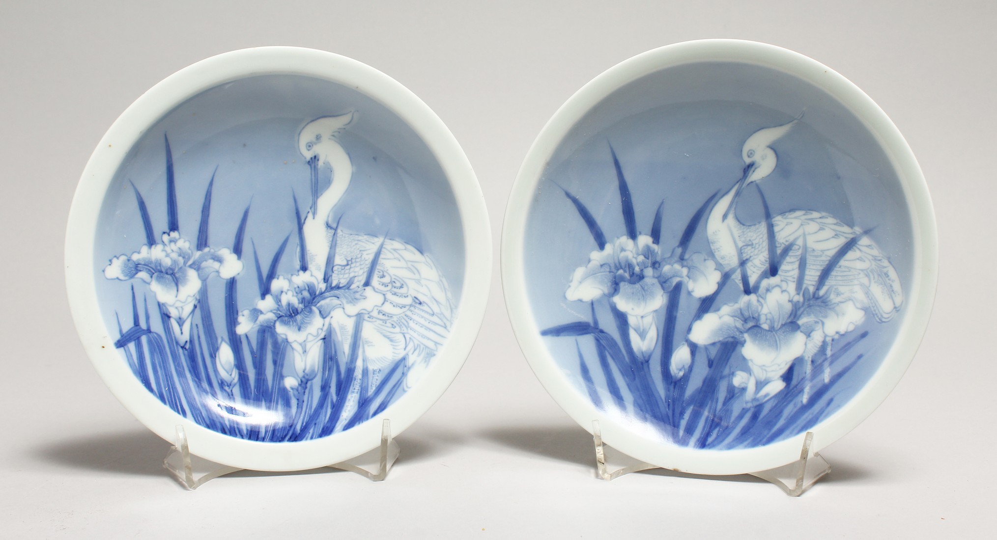 A PAIR OF BLUE AND WHITE PLATES decorated with storks. 7ins diamter.