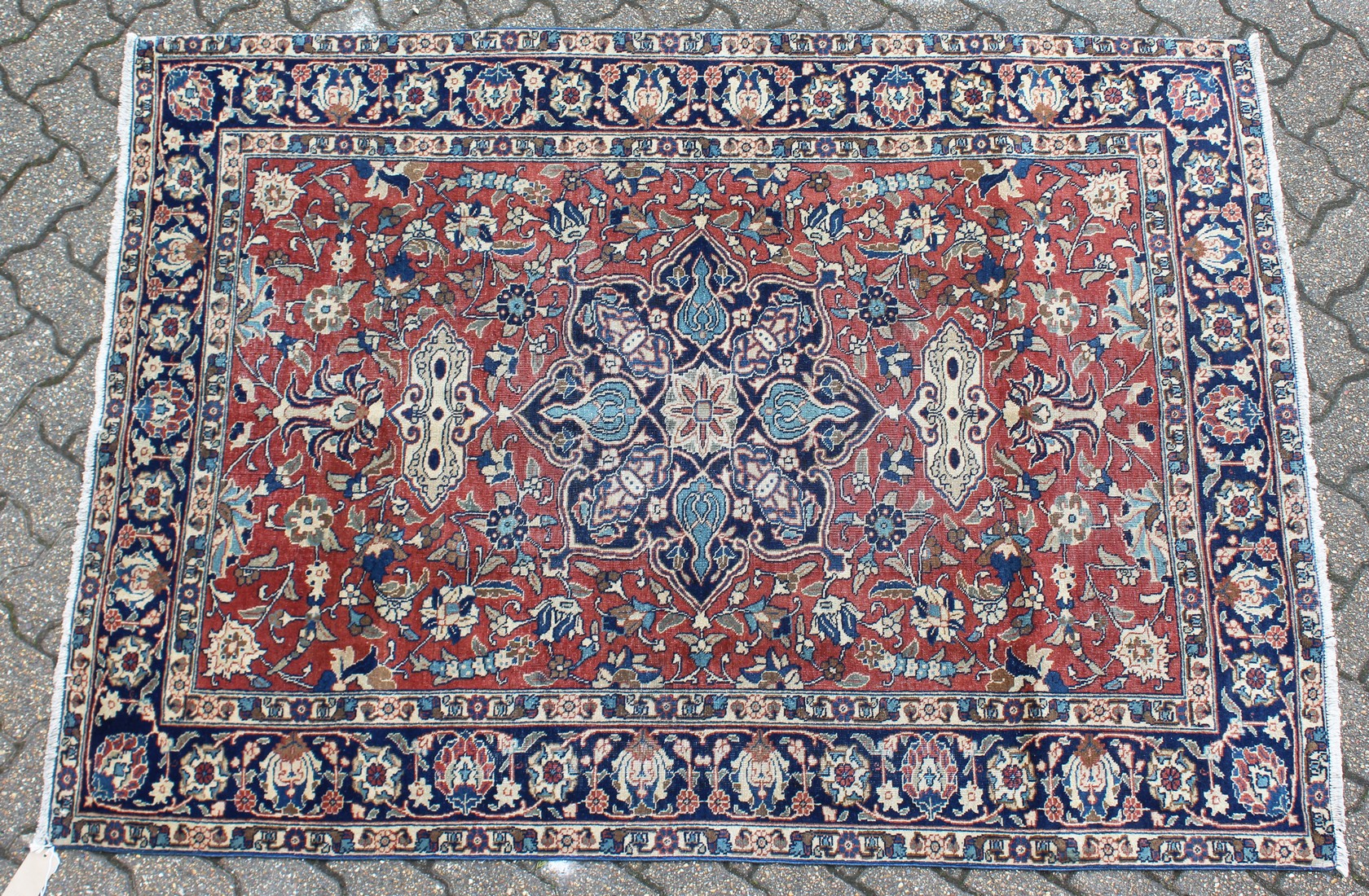 AN EARLY 20TH CENTURY PERSIAN RUG, claret ground with stylised decoration, within a blue ground