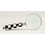 A MAGNIFYING GLASS with a chequered handle.