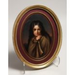 A CONTINENTAL PORCELIN OVAL PLAQUE of a young girl with long hair. 11.5ins x 7.5ins in a wood gilt