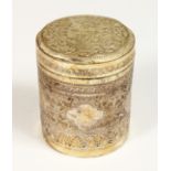 A BURMESE SILVER CIRCULAR BOX AND COVER 3.25ins high, 2.5ins diameter.