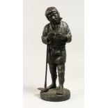 A JAPANESE BRONZE STANDING FIGURE OF A MAN holding a pipe and shovel. 12ins high.