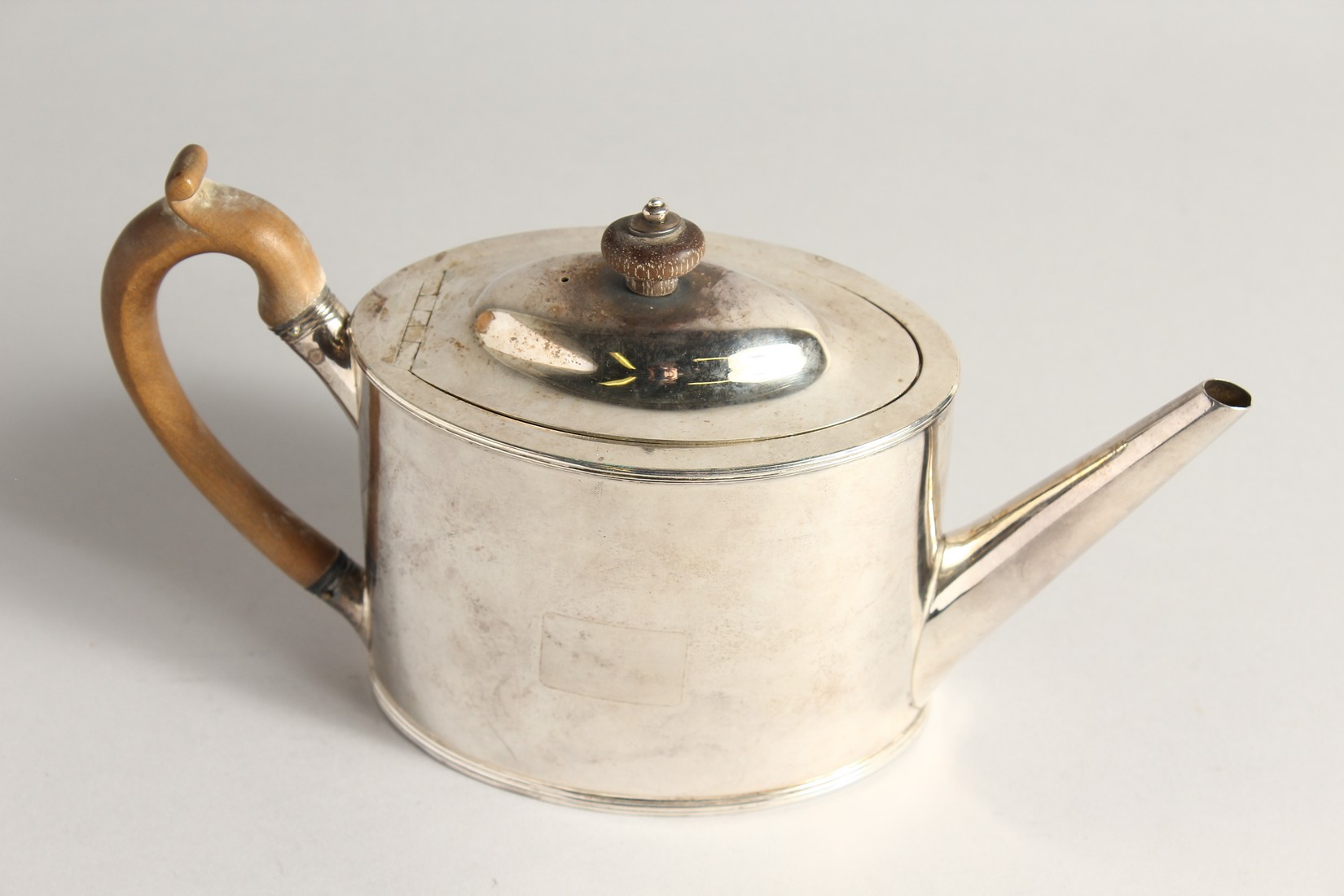 A GEORGE III PLAIN SILVER OVAL TEA POT and cover with wooden handles. London 1789, maker I. O. - Image 2 of 5