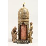A COLD PAINTED BRONZE CIRCULAR TOWER with two men peering in at a naked woman. 12ins high.