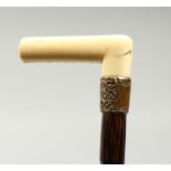 AN EDWARDIAN DANDY CANE with bone handle and gilt collar. 38ins long.