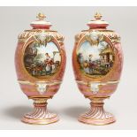 A VERY GOOD PAIR OF SEVRES PINK GROUND VASES AND COVERS each painted with reverse panels of figures,