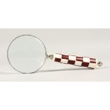 A MAGNIFYING GLASS with a chequered handle.