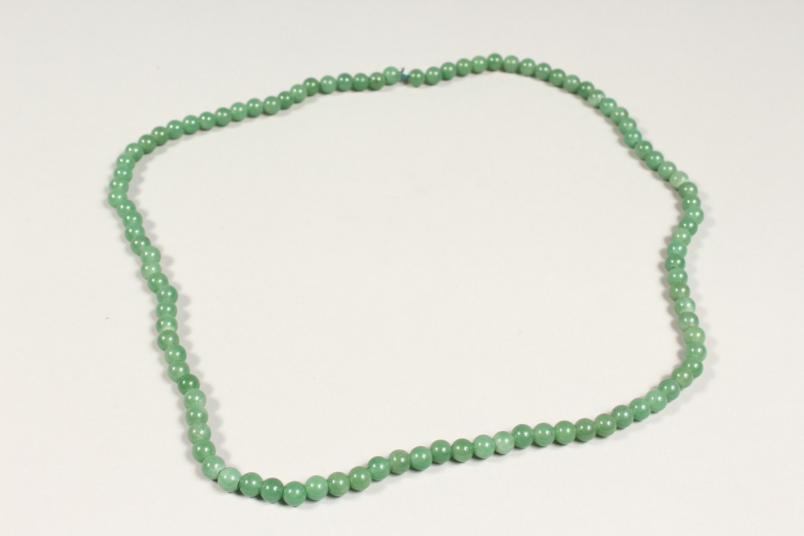 A STRING OF JADE BEADS 24ins long. - Image 2 of 3