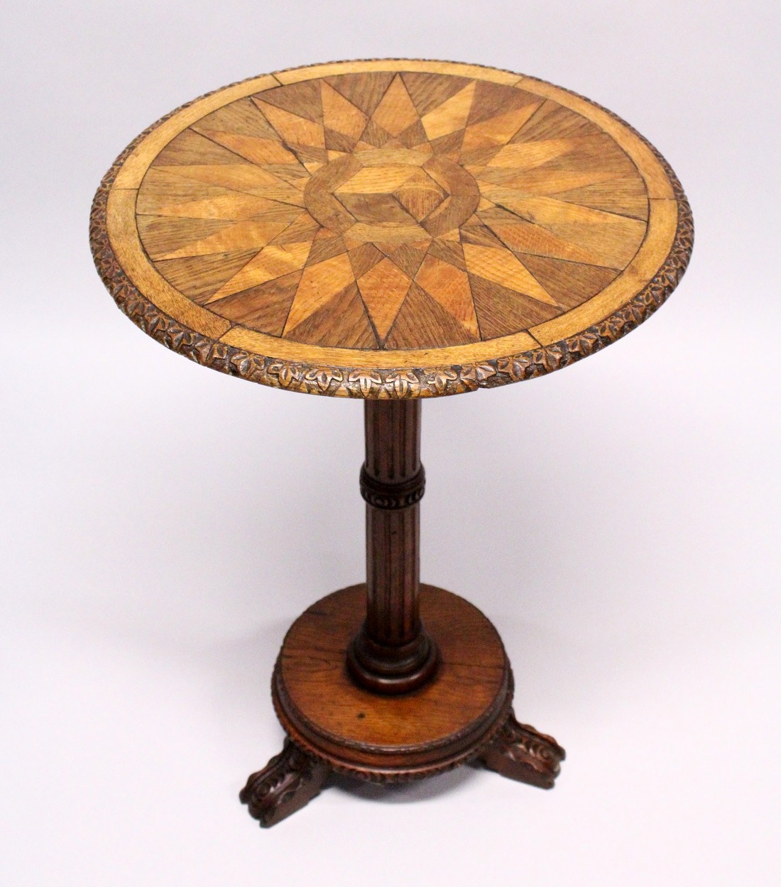 A 19TH CENTURY CIRCULAR TABLE, the star top inlaid with specimen woods on a fluted pillar and