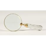 A MAGNIFYING GLASS with a cut glass handle.