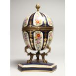 A LARGE SEVRE STYLE BLUE AND GILT EGG SHAPED CASKET AND COVER, painted with flowers on a