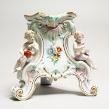 A 19TH CENTURY MEISSE4N PORCELAIN STAND edged in gilt and mounted with three cupids. Cross swords