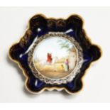 A VIENNA PORCELAIN SHAPED PIN TRAY, blue ground, man on a horse Beehive mark in puce. 4ins
