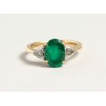 A SUPERB EMERALD AND DIAMOND THREE STONE RING in 18ct gold.