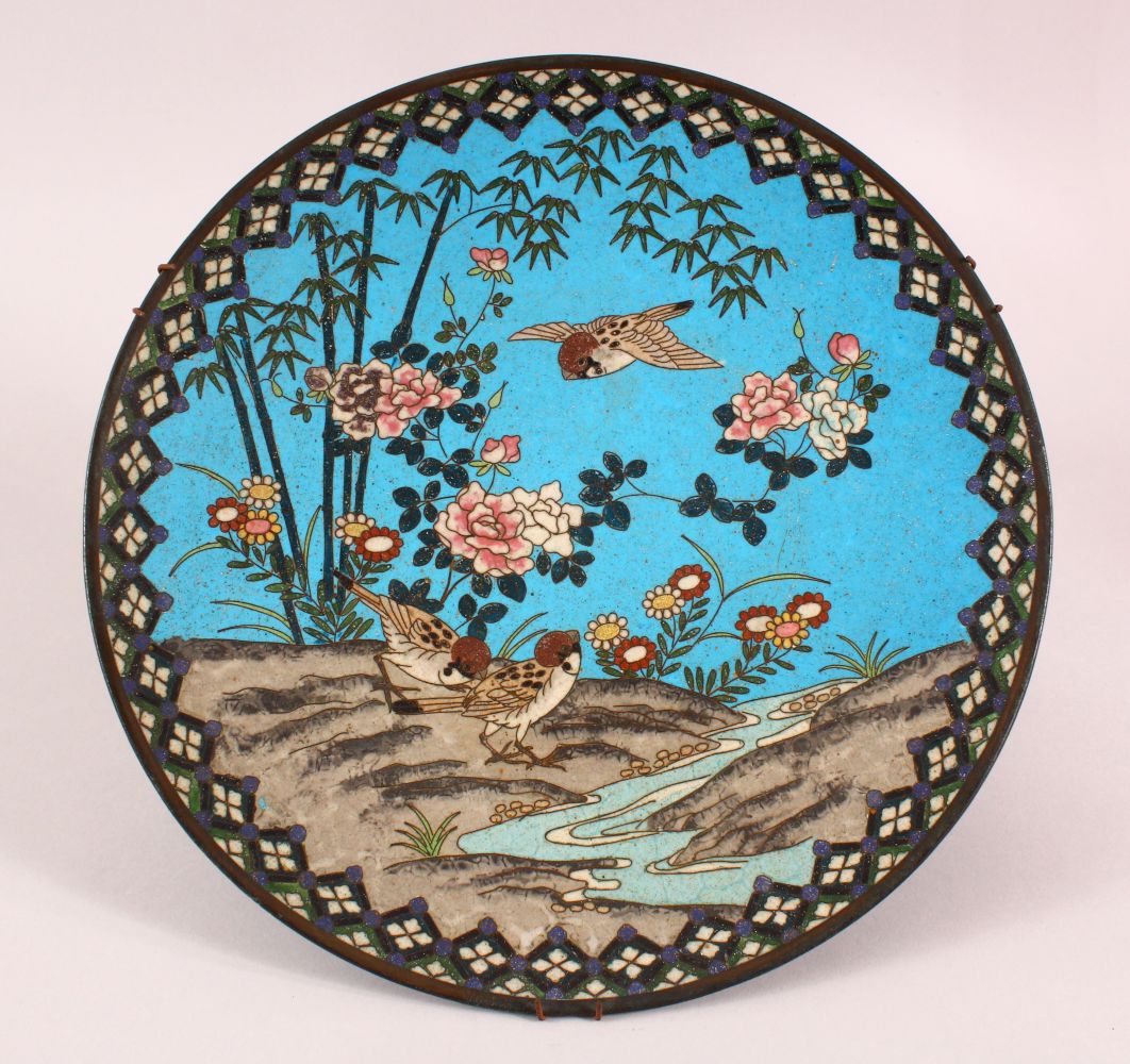 A CLOISONNE CIRCULAR DISH, depicting birds and flowers by a stream, 30cm diameter.