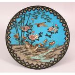 A CLOISONNE CIRCULAR DISH, depicting birds and flowers by a stream, 30cm diameter.