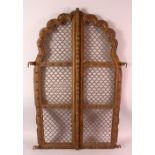 A PAIR OF INDIAN CARVED ROSEWOOD ARCHED WINDOW SHUTTERS, with wire work infill's, 87cm x 27cm