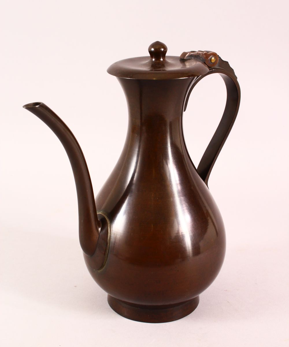 A JAPANESE MEIJI BRONZE TEMPLE EWER, used by monks with a hinged lid, and script to the base, 26cm