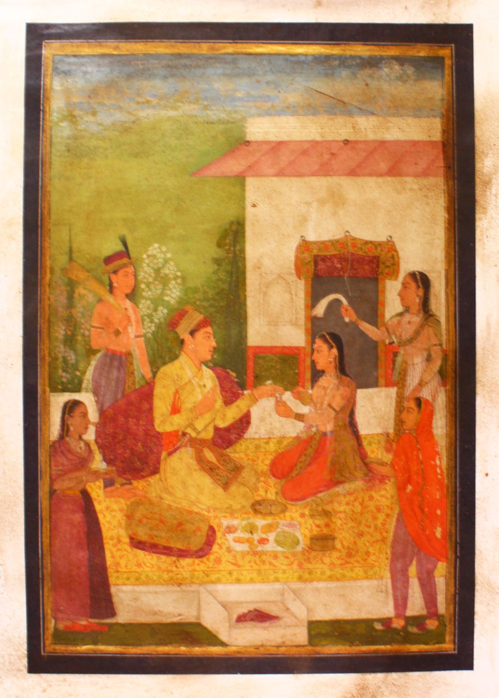 AN INDIAN PAINTING ON CANVASS OF PRINCE AND ATTENDANTS, seated in the garden having a picnic, 83cm x