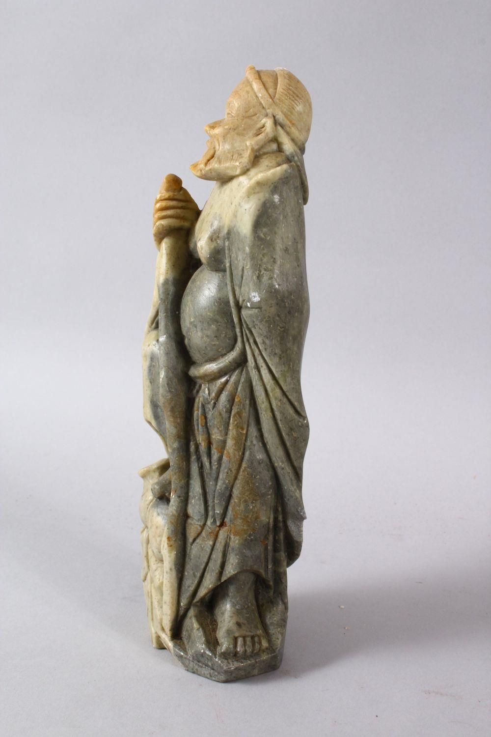 A LARGE CHINESE SOAPSTONE CARVING OF AN IMMORTAL, stood upon a rocky outcrop with a double groud, - Image 4 of 6