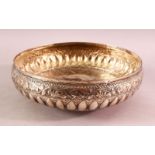 A 19TH CENTURY INDIAN SILVER BOWL, with pressed decoration on three feet, 24cm