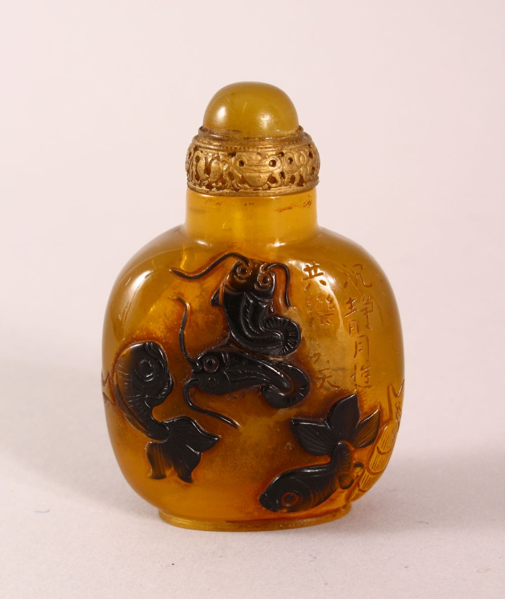 A CHINESE OVERLAID AMBER STYLE SNUFF BOTTLE, with overlay style decoration of fish, with incised