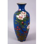 A JAPANESE MEIJI PERIOD CLOISONNE VASE, the blue ground with native display of flora, 24cm high