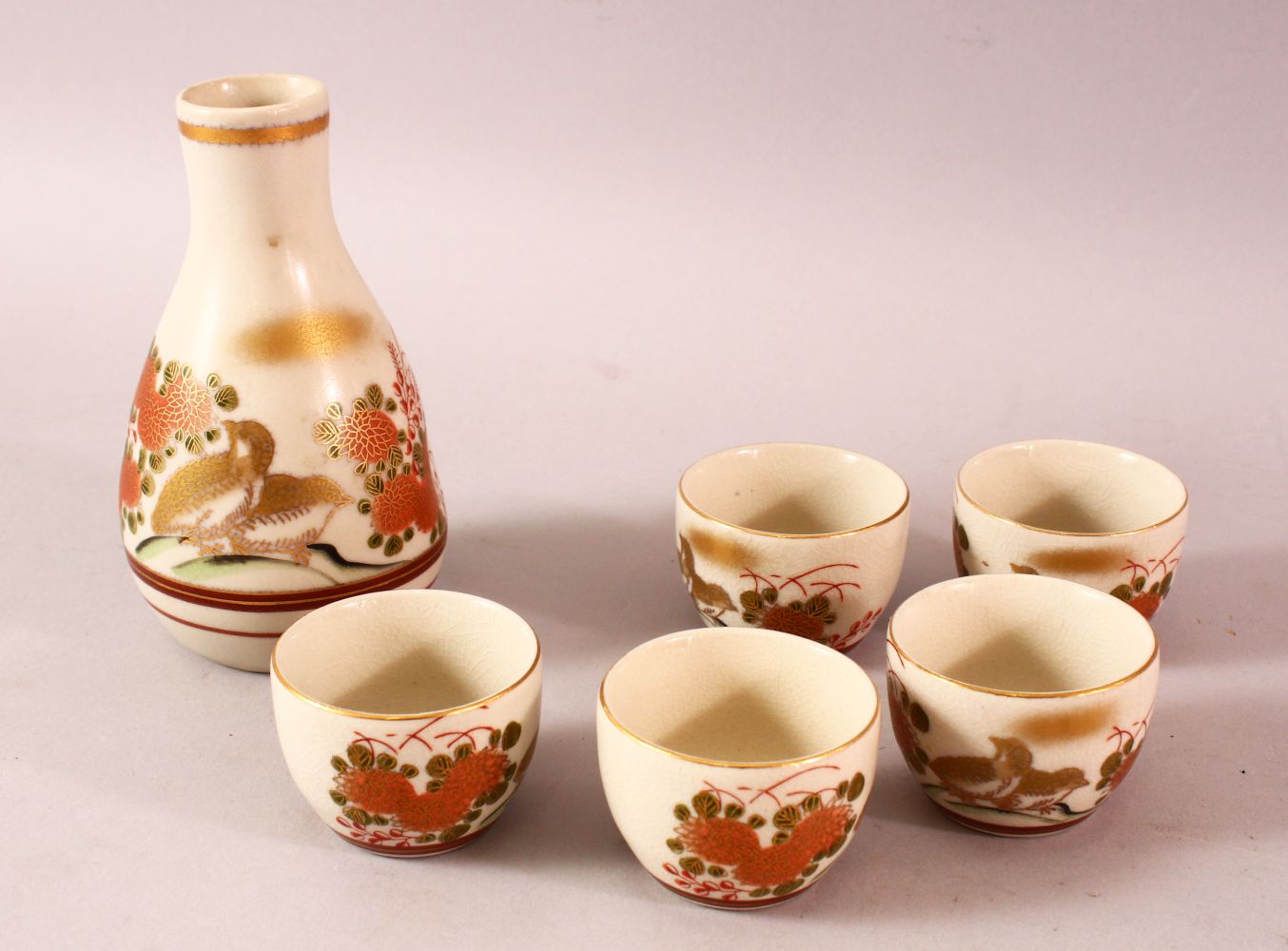 A JAPANESE PORCELAIN SAKE SET, five cups and one bottle, decorated with quail and flora, 13cm the