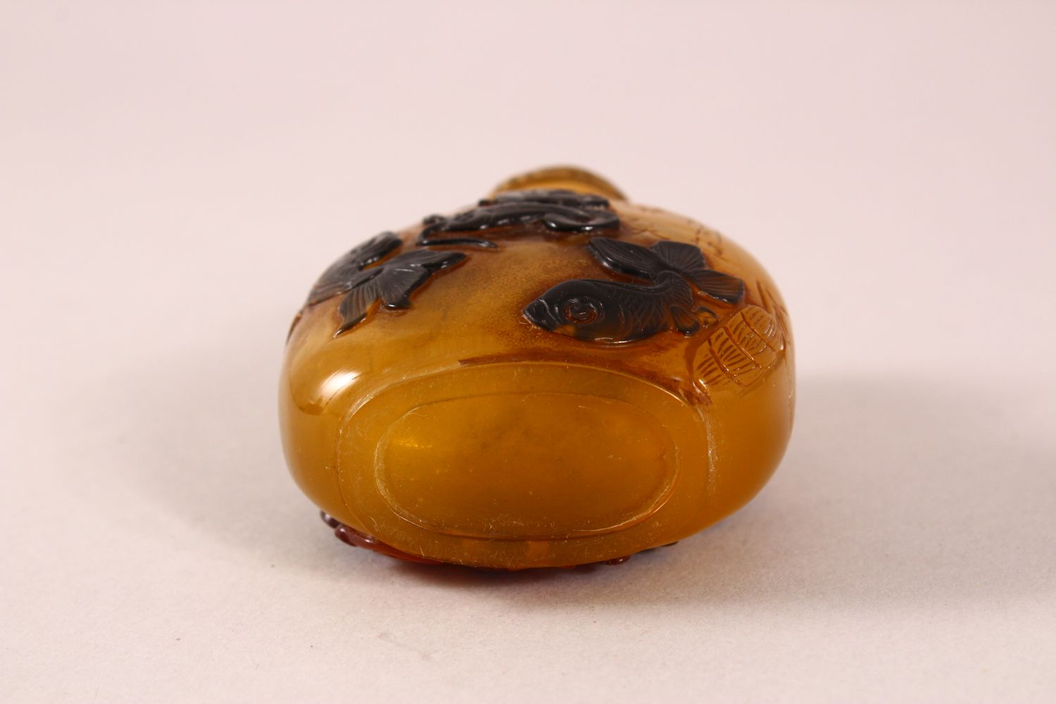 A CHINESE OVERLAID AMBER STYLE SNUFF BOTTLE, with overlay style decoration of fish, with incised - Image 5 of 5