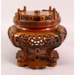 A JAPANESE MEIJI PERIOD CARVED WOODEN REVOLVING VASE STAND, with carved frieze panels of flora, on