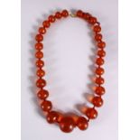 A 19TH CENTURY CHINESE CARVED AMBER BEAD NECKLACE, comprising 29 graduated size carved amber