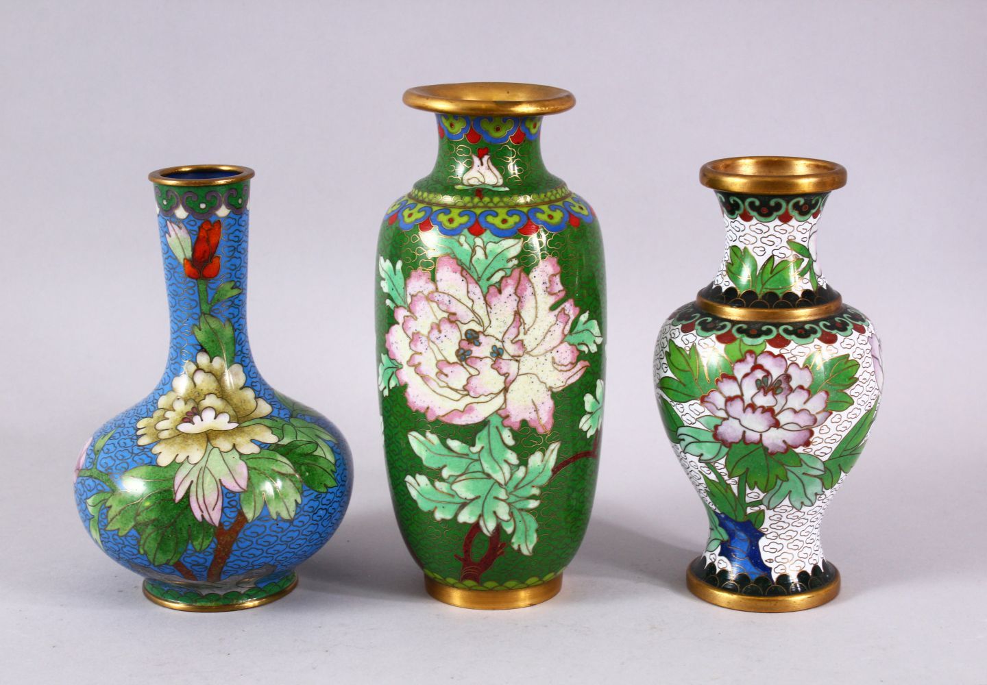 A MIXED LOT OF THREE CHINESE CLOISONNE VASES - the largest with a green ground with native Lotus