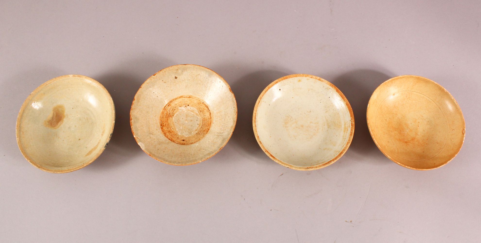 FOUR EARLY CHINESE POTTERY BOWLS, of varying style and size (4)