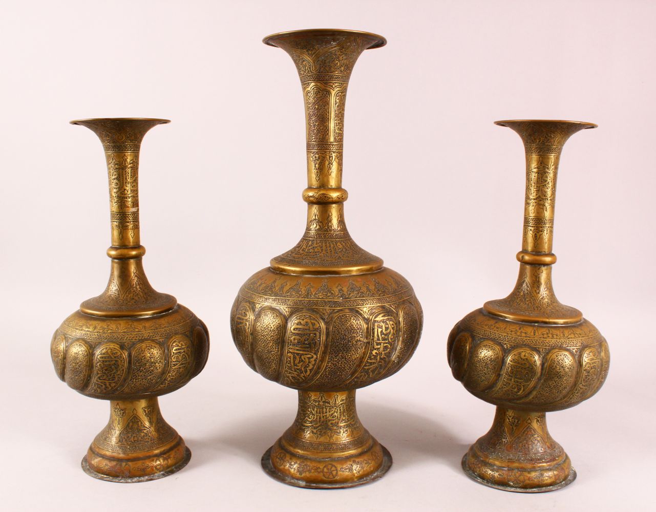THREE PERSIAN ISLAMIC CALLIGRAPHIC BRASS VASES, each with calligraphy and motif decoration, 43cm ,