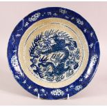 A CHINESE CRACKLE GLAZED PORCELAIN DISH, decorated with dragons and flora, 28cm diameter.