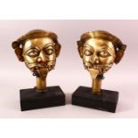 A PAIR OF 19TH / 19TH CENTURY SOUTH INDIAN BRASS MASKS OF SHIVA, each mounted on wooden bases,