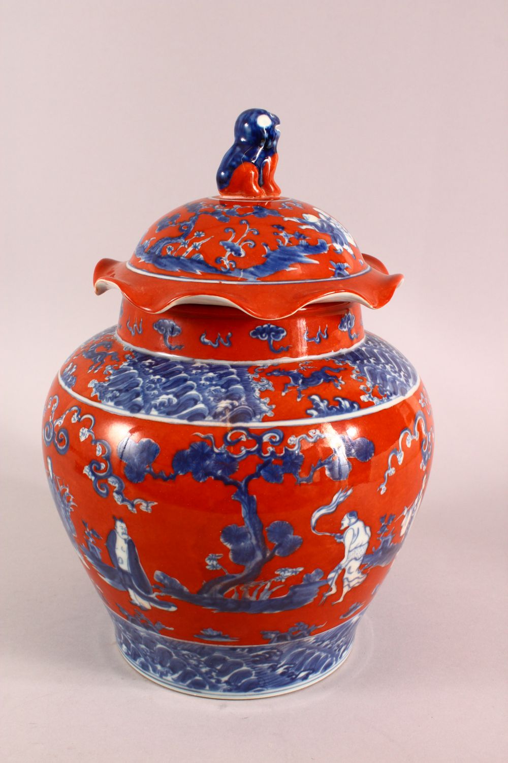 A CHINESE CORAL RED GROUND UNDERGLAZE BLUE PORCELAIN GINGER JAR & COVER, decorated with immortals in - Image 3 of 10
