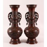 A PAIR OF JAPANESE RELIEF BRONZE VASES, with twin handles, relief birds and flora decoration, 40cm