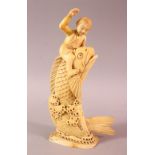 A JAPANESE MEIJI PERIOD CARVED IVORY FISH OKIMONO, the fish emerging from the water with a boy on